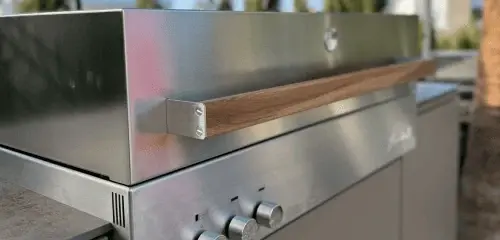 Moderner Edelstahl-Gasgrill mit Holzgriff und Temperaturreglern für Outdoor-Küche.