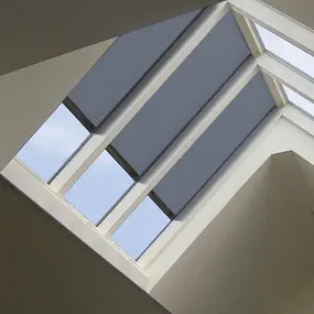 Modernes Dachfenster mit Sonnenschutzrollos und Tageslichteinfall im Innenraum.